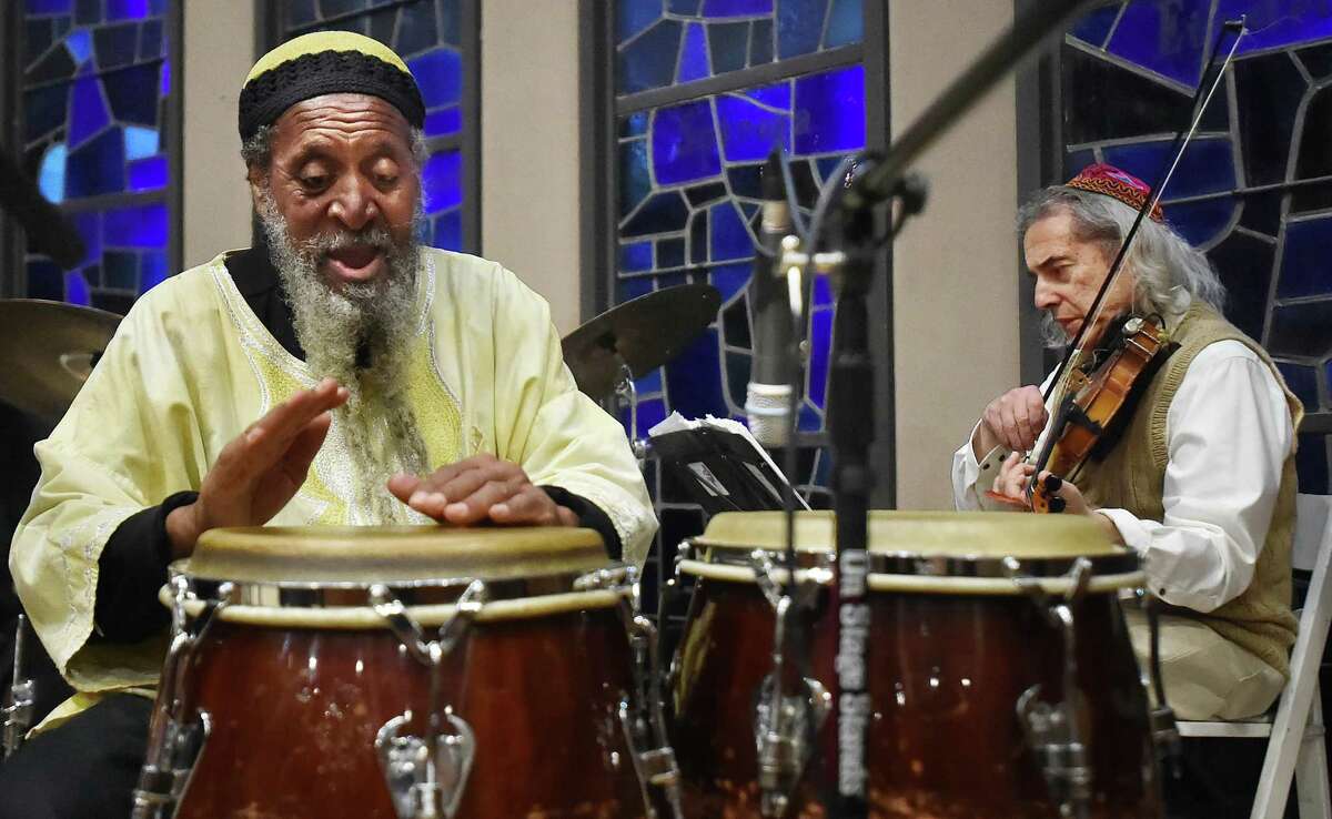 Alvin Abu Carter plays the congos with violinist Stacy Phillips, members of the Afro-Semitic Experience, at the annual interfaith service in tribute to the Rev. Martin Luther King Jr. at Congregation Mishkan Israel in Hamden Friday.