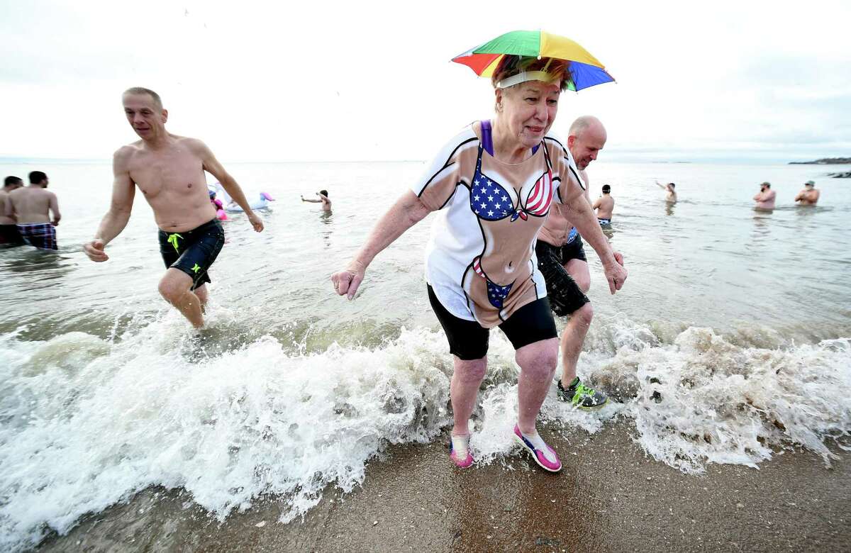 Sandy Kline (right) of New Haven emerges from the water during the 18th annual Icy Plunge for the Cure to benefit the West Haven Breast Cancer Awareness Program at Savin Rock Beach in West Haven on January 13, 2018.