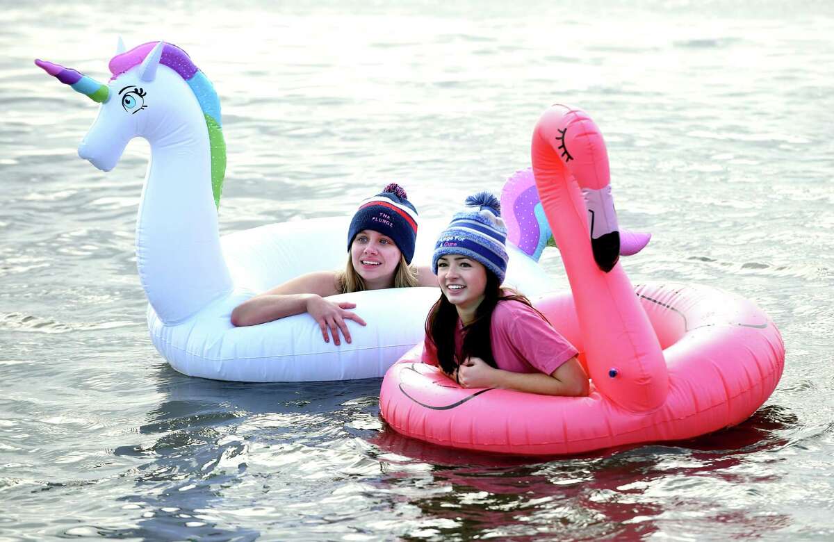 Elyssa Dalaker (left), 17, and her friend, Catie Beckwith, 17, of West Haven float in the Long Island Sound during the 18th annual Icy Plunge for the Cure to benefit the West Haven Breast Cancer Awareness Program at Savin Rock Beach in West Haven on January 13, 2018.