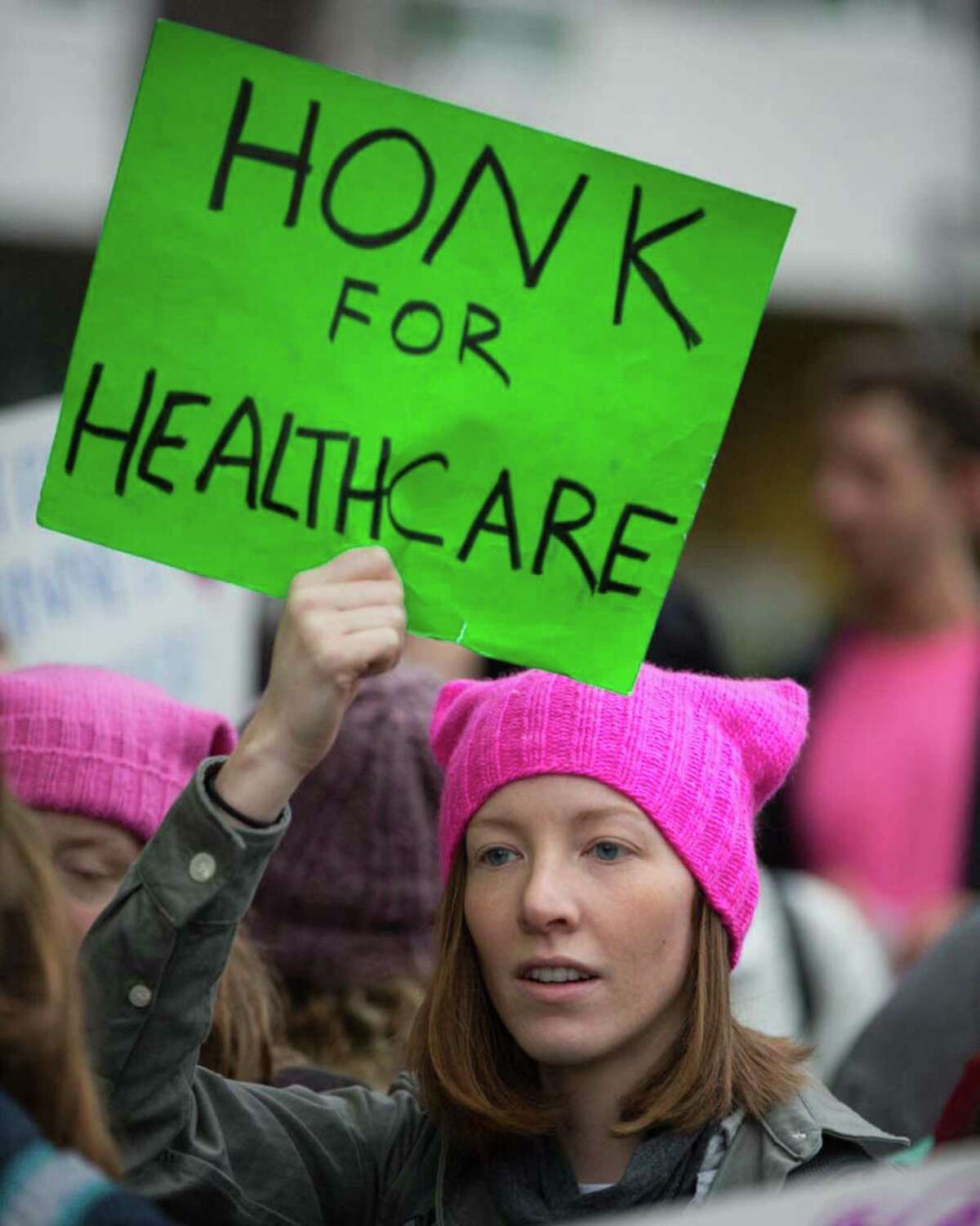 A women's rights supporter holds a sign up to traffic to counter protesters of the Capitol Hill Planned Parenthood on Saturday, Jan. 13, 2018.