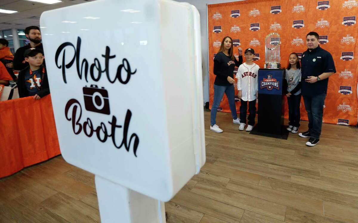 Fans get their photos taken with the Astros Championship trophy during the Astros Fan Fest at. inute Maid Park, Saturday, Jan. 13, 2018, in Houston.