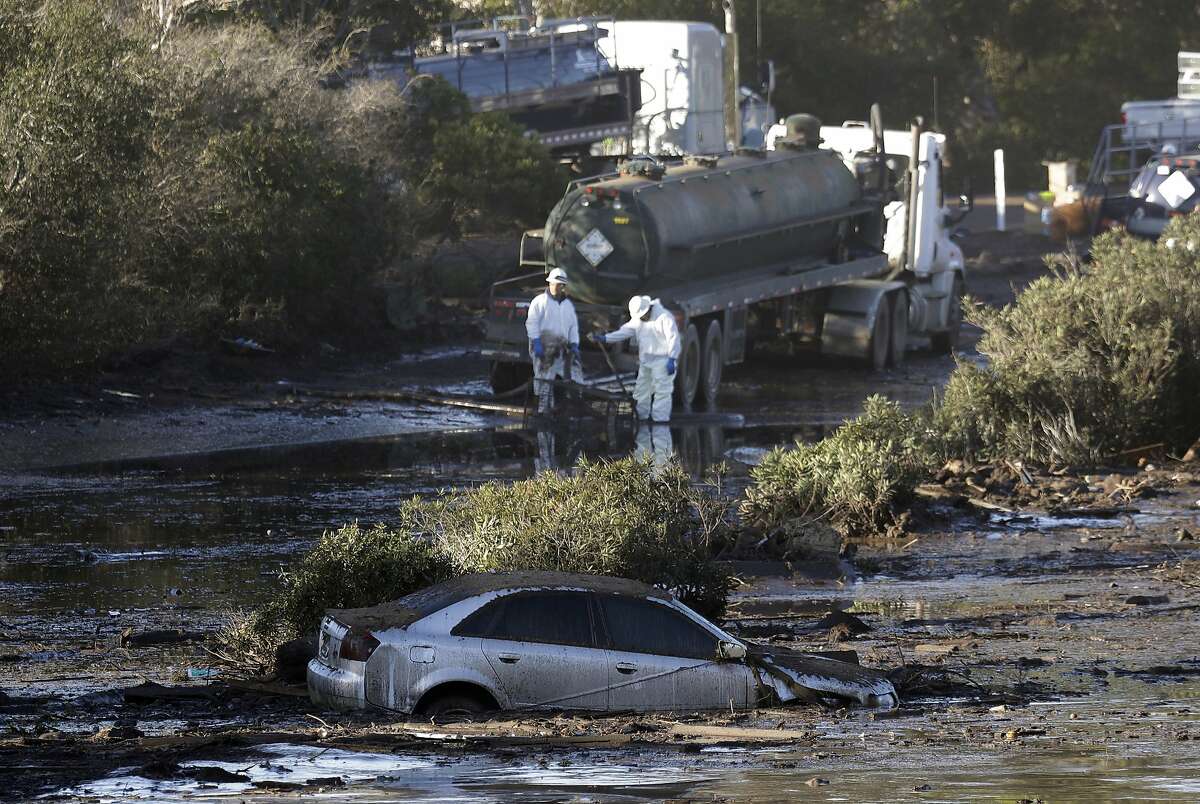 Crews pump mud on Highway 101 after a mudslide Saturday, Jan. 13, 2018, in Montecito, Calif. Most of the people of Montecito, a town usually known for its serenity and luxury, were under orders to stay out of town as gas and power were expected to be shut off Saturday for repairs. (AP Photo/Marcio Jose Sanchez)