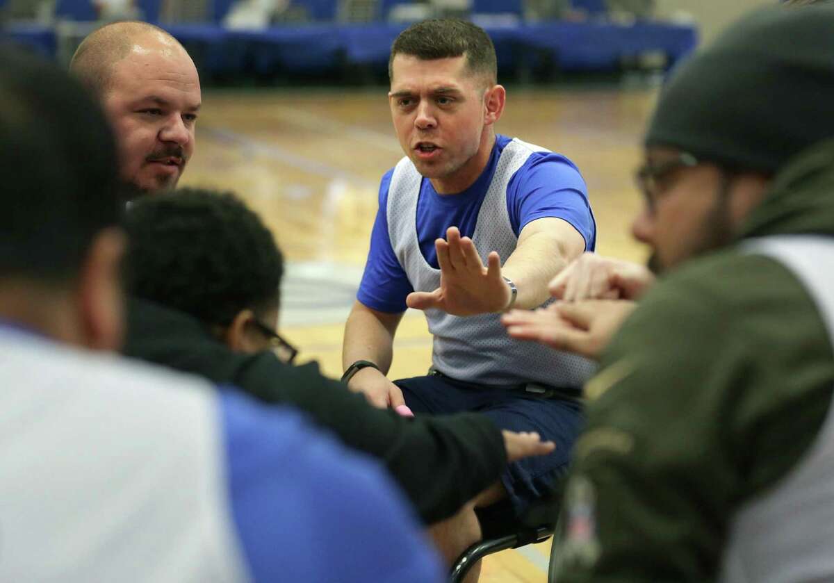 Tech Sgt. Trevor Brewer, center, joins in a team cheer before a wheelchair basketball game at the Air Force Wounded Warrior event at Joint Base San Antonio-Randolph, on Friday, Jan. 12, 2018.