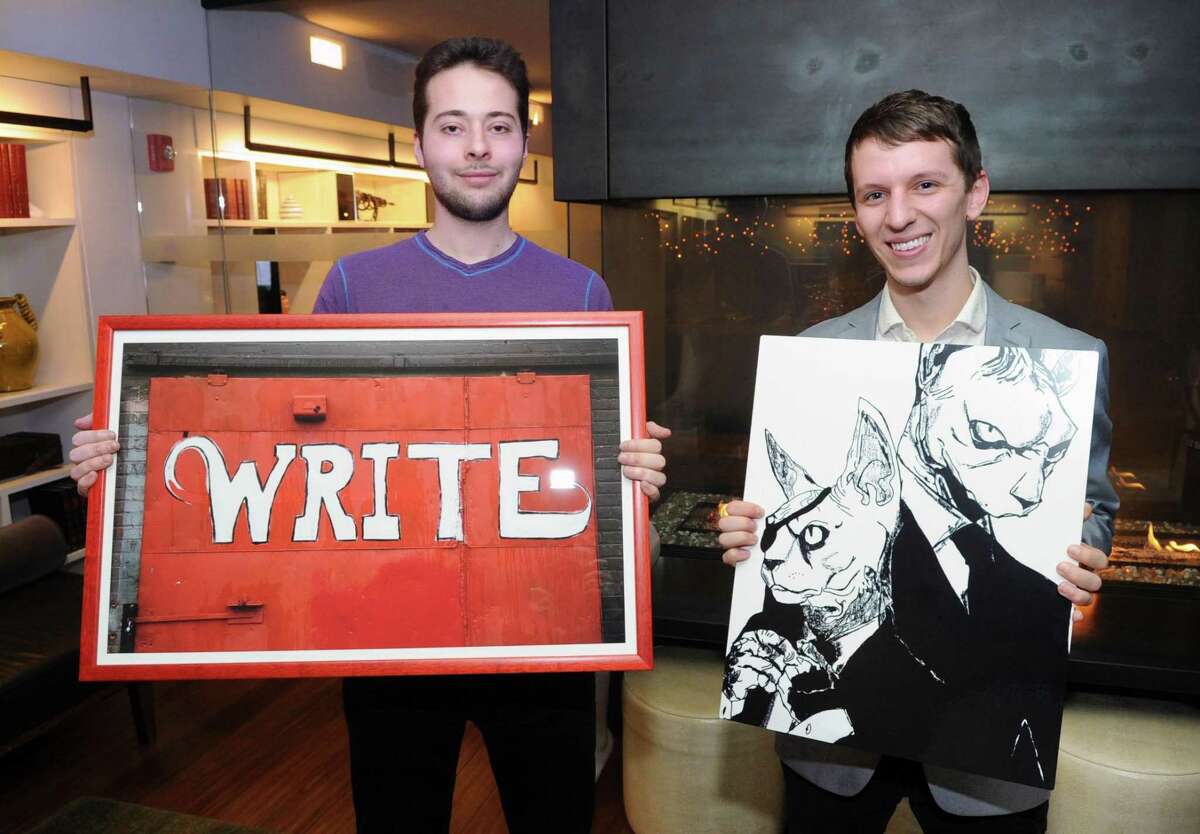 J House Greenwich staff members Christian Gillis, left, and Mike Fusciardi with their artwork that will be featured as part of an upcoming employees art show at the J House Greenwich hotel in Greenwich, Conn., Friday, Jan. 12, 2018. Gillis is holding a photo he took of the side of a red building with the word "Write" painted in white on it, taken in Asheville, N.C., Fusciardi holds a graphic artwork inspired by his cats titled "Feline Good." Fellow staff member Meg Foster will also display her art at the exhibition.