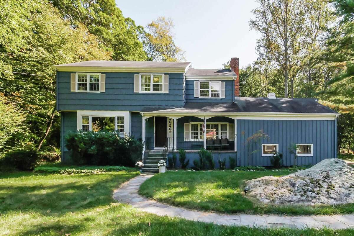 The blue colonial house at 15 Mail Coach Drive sits in Norwalk while the 1.19-acre level property on which it sits is in both Wilton and Norwalk.