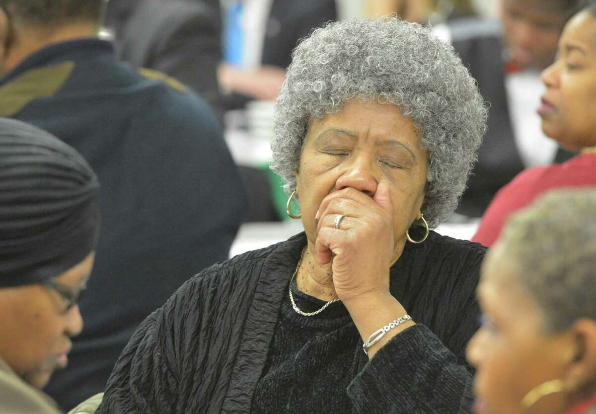 Rosamae Brown closes her eyes during prayer with others at the Community Breakfast in observance of Rev. Dr. Martin Luther King, Jr. at West Rocks School on Monday January 15, 2018 in Norwalk Conn.