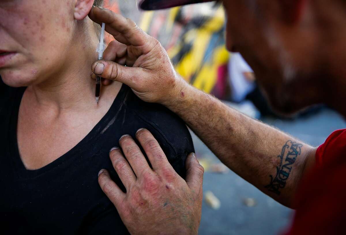 Shawn attempts to inject Molly with heroin in her neck on Larkin Street in San Francisco, Calif., on Thursday, Oct. 26, 2017.