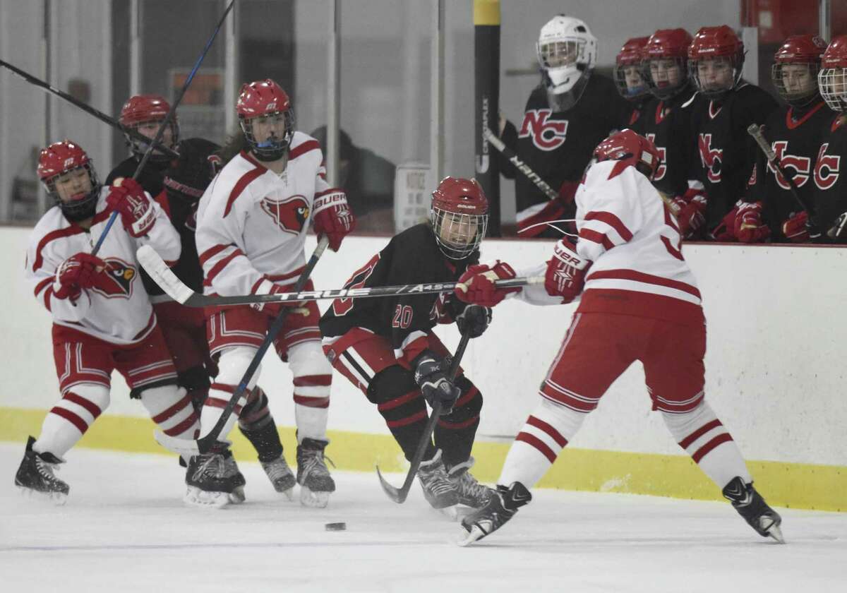 New Canaan's Quincy Connell (20) splits a group of Greenwich defenders in Greenwich's 4-1 win over New Canaan in the high school girls hockey game at Dorothy Hamill Skating Rink in Greenwich, Conn. Monday, Jan. 15, 2018.