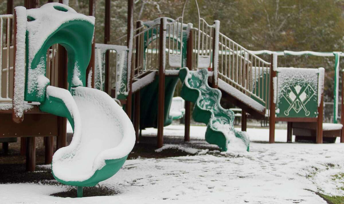 Snow and ice cover a children's playground at Carl Barton Jr. Park, Friday, Dec. 8, 2017, in Conroe.