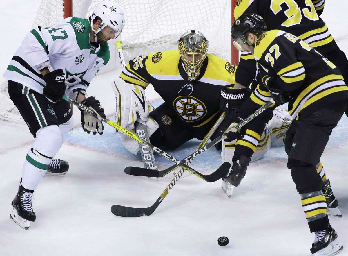 Dallas Stars right wing Alexander Radulov, of Russia, left, vies for control of the puck with Boston Bruins center Patrice Bergeron, right, as Bruins goaltender Anton Khudobin, center, guards the net in the third period of an NHL hockey game, Monday, Jan. 15, 2018, in Boston. The Stars won 3-2 in overtime. (AP Photo/Steven Senne)