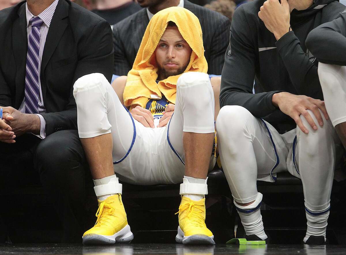 Golden State Warriors guard Stephen Curry sits on the bench in the fourth quarter in Cleveland.