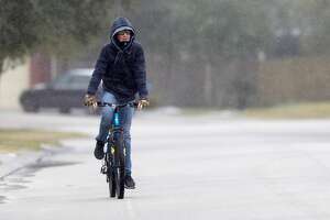 William Johnson, 14, rides his bike as sleet rains down after a winter storm brought freezing rain and ice throughout the greater Houston area, Tuesday, Jan. 16, 2018. The National Weather Service issued a Winter Storm Warning for southeast Texas until midnight Wednesday.