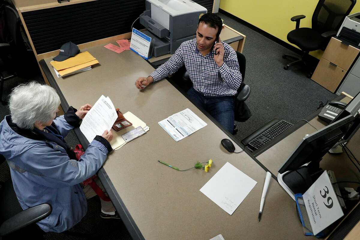 Senior Analyst Omar Masry helps Marcy Lipton with her paperwork for hosting guests at the Office of Short Term Rentals in San Francisco. After January 16, Airbnb and rival site HomeAway/VRBO are obligated to ditch any San Francisco hosts who’ve failed to register with the city, under terms of a legal agreement.