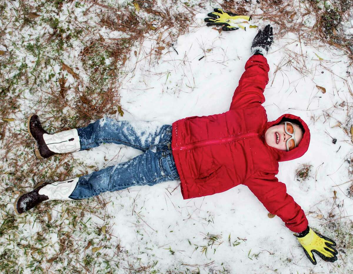 Zach Arnold tries to make a snow angel while playing in the snow on Tuesday, Jan. 16, 2018, in Spring. ( Brett Coomer / Houston Chronicle )
