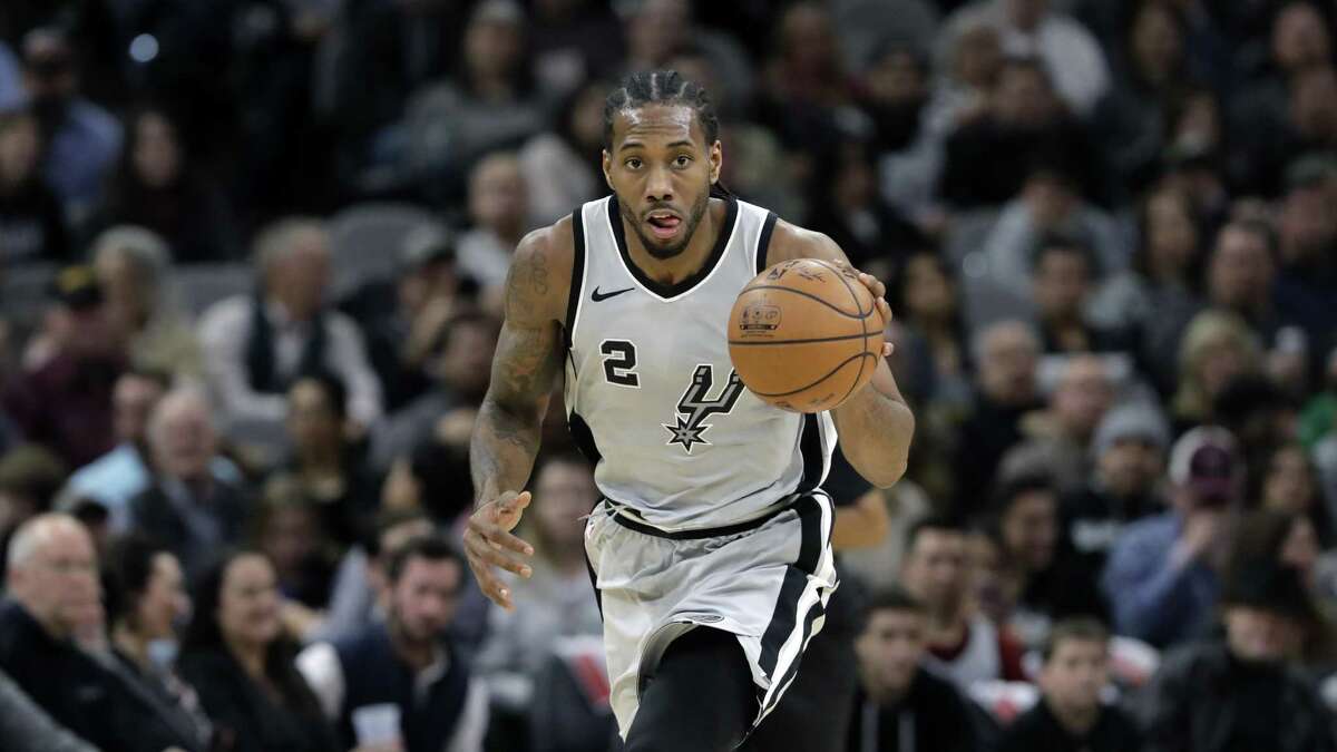 San Antonio Spurs forward Kawhi Leonard (2) moves the ball up court during the second half of an NBA basketball game against the Denver Nuggets, Saturday, Jan. 13, 2018, in San Antonio. San Antonio won 112-80.