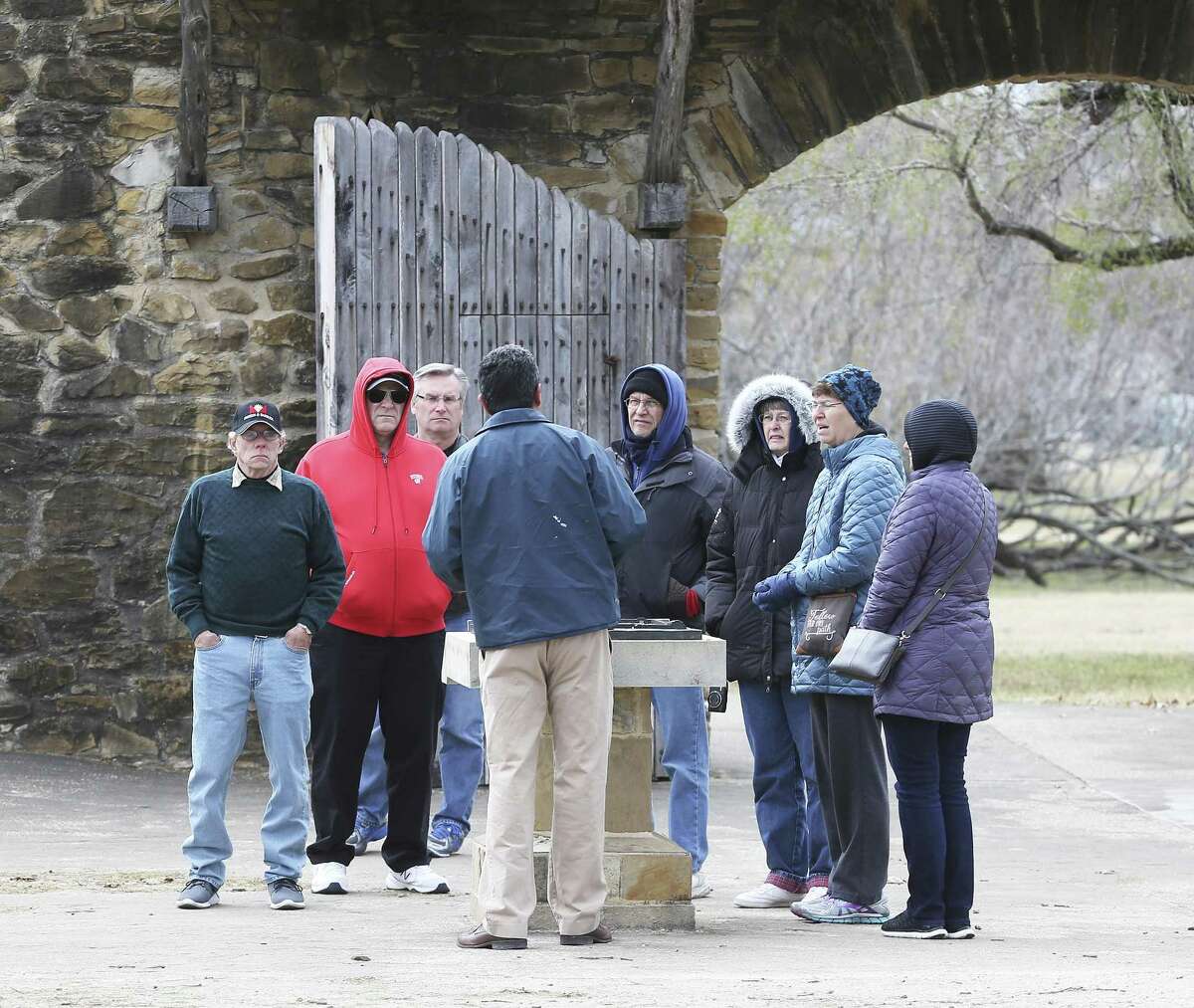 Visitors listen to a tour guide near the entrance of Mission San Jose on January 17, 2018