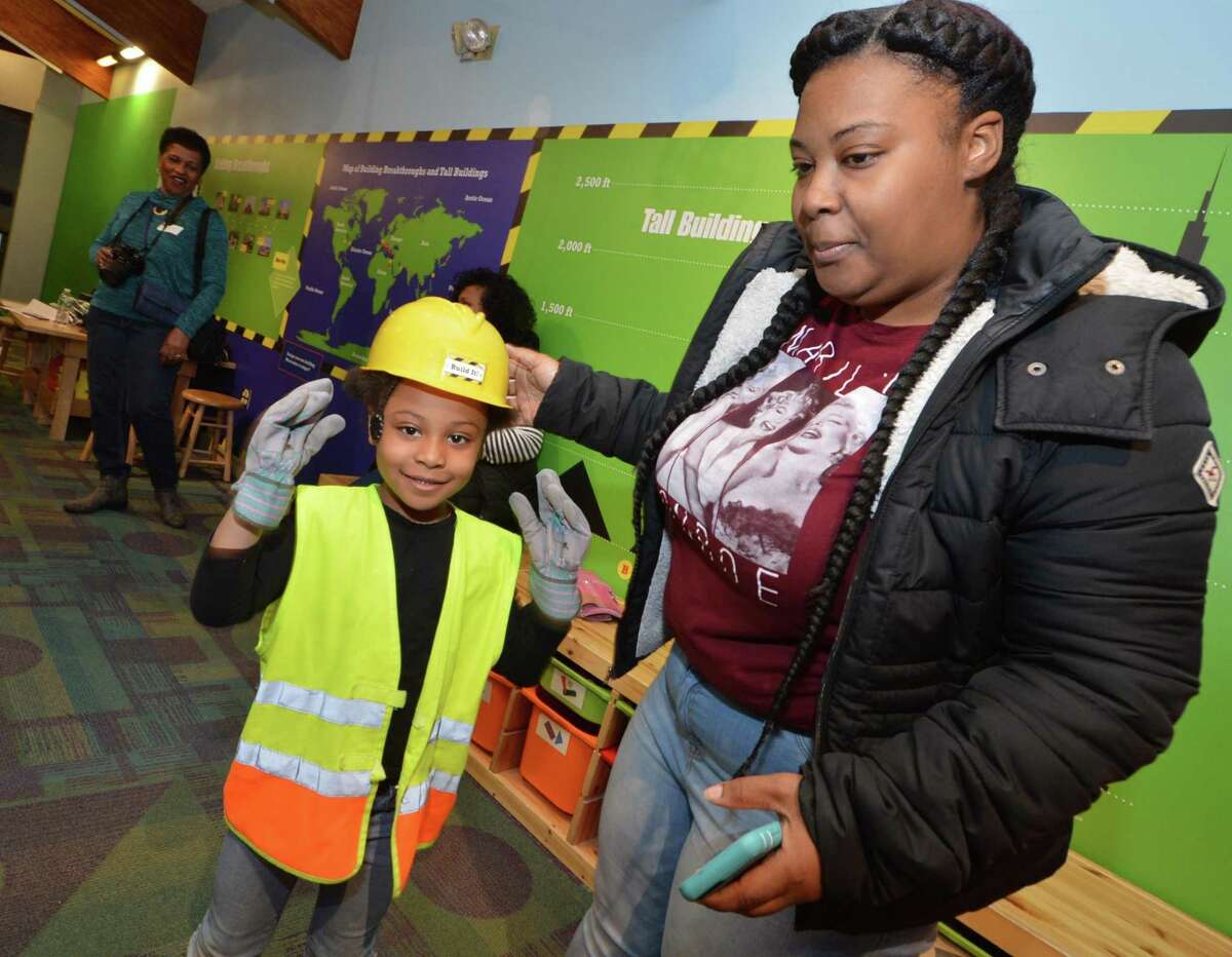 Whitney William helps her daughter Londyn with her hard hat in the construction display during the Norwalk Mentor Program annual party Wednesday at Stepping Stones Museum for Children to celebrate the 250 mentors, mentees and families that take part in the program.