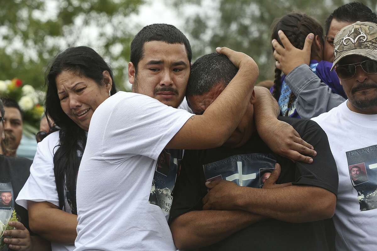 Pete Alvarado embraces his father, Pedro Alvardo, next to Pete's mother, Raquel Alvarado, during the burial for his siblings and their children, Erica Alvarado Rivera, 26, Alex Alvarado, 22, and Jose Angel Alvarado, 21, in El Control, Mexico on Sunday, November, 2, 2014. The siblings, U.S. Citizens from Progreso were found shot to death more than two weeks after they went missing from a restaurant near El Control.