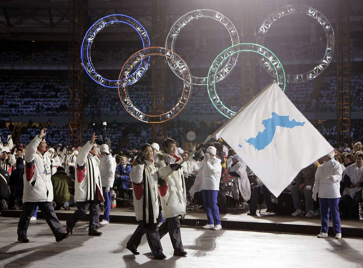 FILE - In this Feb. 10, 2006, file photo, Korea's flag-bearers Bora Lee and Jong-In Lee, carrying a unification flag lead their teams into the stadium during the 2006 Winter Olympics opening ceremony in Turin, Italy. When athletes of the rival Koreas walked together behind a single flag for the first time since their 1945 division at the start of the 2000 Sydney Olympics, it was a highly emotional event that came on the wave of reconciliation mood following their leaders� first-ever summit talks. Eighteen years later, now, the Koreas are pushing to produce a similar drama during the upcoming Pyeongchang Olympics. But they haven�t generated as much enthusiastic supports as they had both at home and abroad. (AP Photo/Amy Sancetta, File)