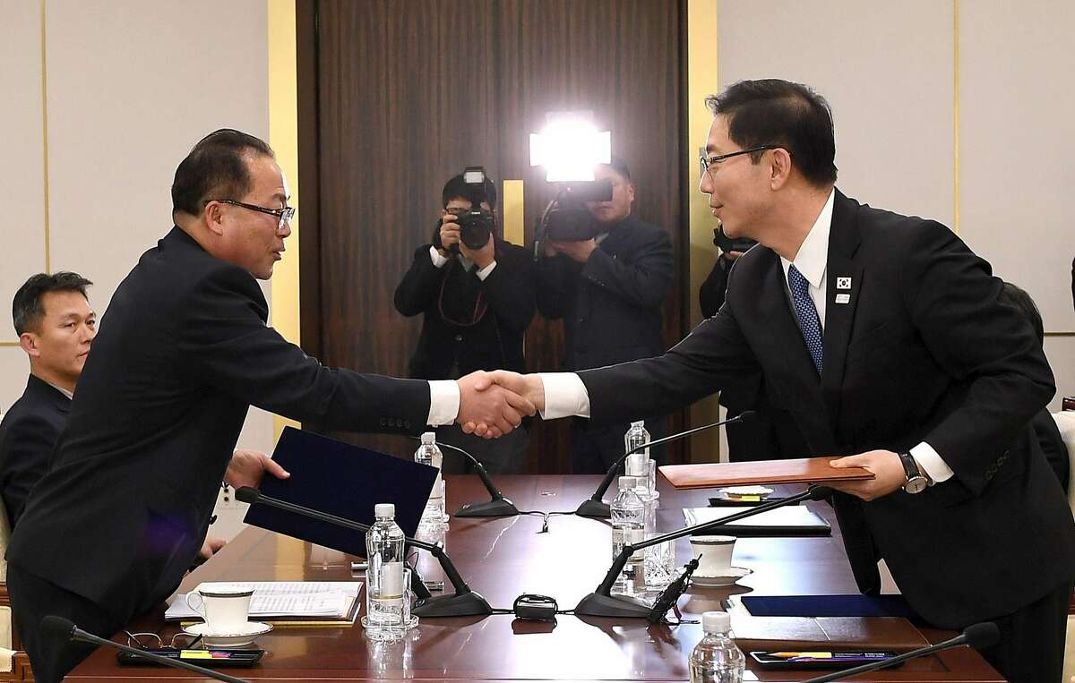 TOPSHOT - This handout photo provided by South Korean Unification Ministry on January 17, 2018 shows South Korean chief delegate Chun Hae-Sung (R) shaking hands with North Korean chief delegate Jon Jong-Su (L) as they exchange joint statements during their working-level talks at the South side of the border truce village of Panmunjom in the Demilitarized zone dividing the two Koreas. The two Koreas agreed on January 17 to march together under a single flag at the Winter Olympics opening ceremony and field a united women's ice hockey team for the Games in a further sign of easing tensions on the peninsula. / AFP PHOTO / AFP PHOTO AND South Korean Unification Ministry / handout / RESTRICTED TO EDITORIAL USE - MANDATORY CREDIT "AFP PHOTO / South Korean Unification Ministry" - NO MARKETING NO ADVERTISING CAMPAIGNS - DISTRIBUTED AS A SERVICE TO CLIENTS HANDOUT/AFP/Getty Images