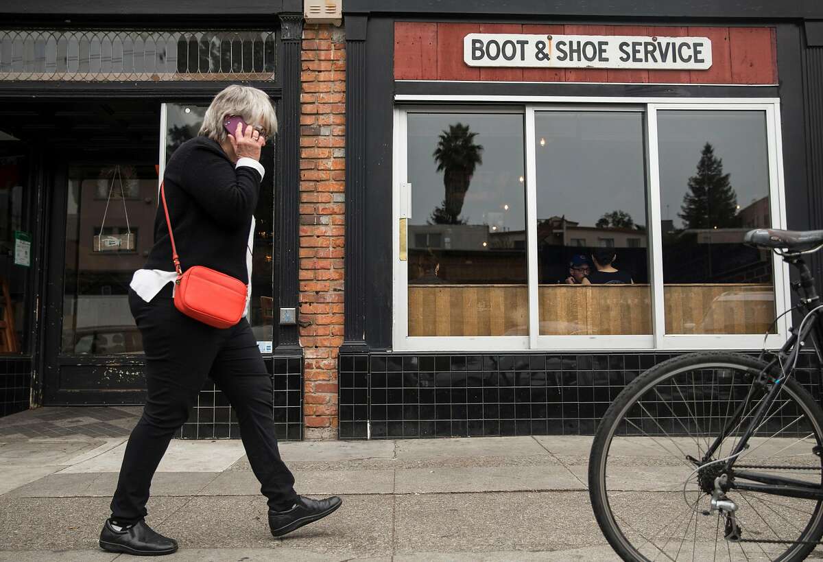 A woman walks past Boots & Shoe Service Thursday, Jan. 18, 2018 in Oakland, Calif.