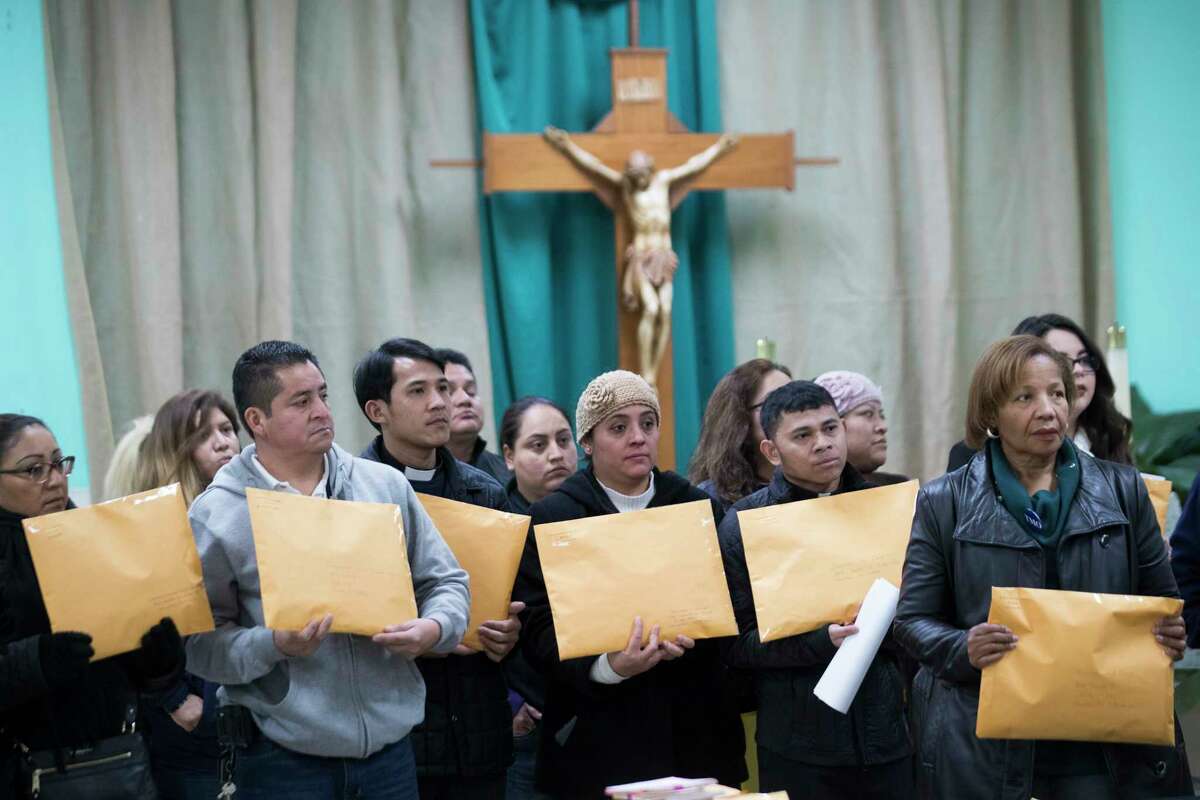Members of the community and clergy hold envelopes with postcards addressed to legislators asking them to support Deferred Action for Childhood Arrivals (DACA) recipients and keep families together. More than 20,000 postcards are being sent. Thursday, Jan. 18, 2018, in Houston. ( Marie D. De Jesus / Houston Chronicle )