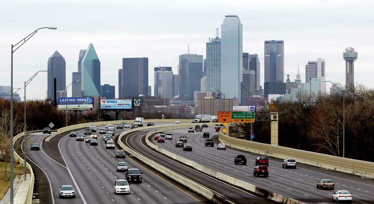 FILE - This Friday, Jan. 14, 2011, file photo shows highway IH-30 traffic with the Dallas skyline in the background. Dallas is one of the many cities vying to land Amazon's second headquarters. While Texas cities vying to land the new headquarters have been vocal about why they think they should win, they've resisted releasing copies of their proposals. (AP Photo/Tony Gutierrez, File)
