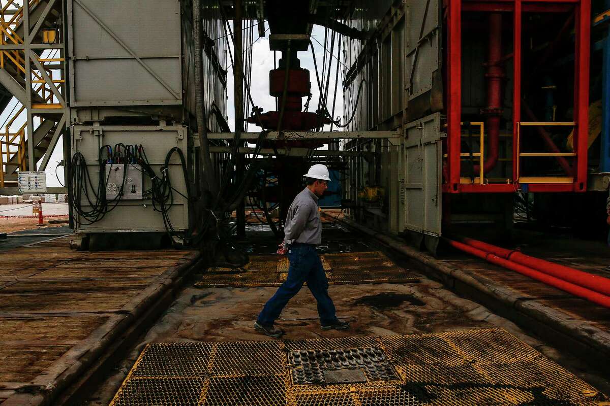 A worker walks across a pad site where a drilling rig will create three to six wells next to each other at a Chevron drilling and hydraulic fracturing site Wednesday, July 19, 2017 in Midland. ( Michael Ciaglo / Houston Chronicle )