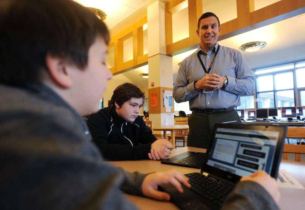 From left; Seventh graders Jeffrey Wojtowicz and Damon Holm, both 12, receive guidance from library media specialist Ron Gydus during library learning time at Shelton Intermediate School in Shelton on Tuesday, January 16, 2018.