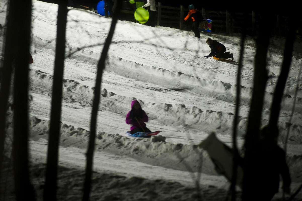 People fly down the sledding hill during the Snow and Glow event at Midland City Forest on Friday, Jan. 19, 2018. (Katy Kildee/kkildee@mdn.net)