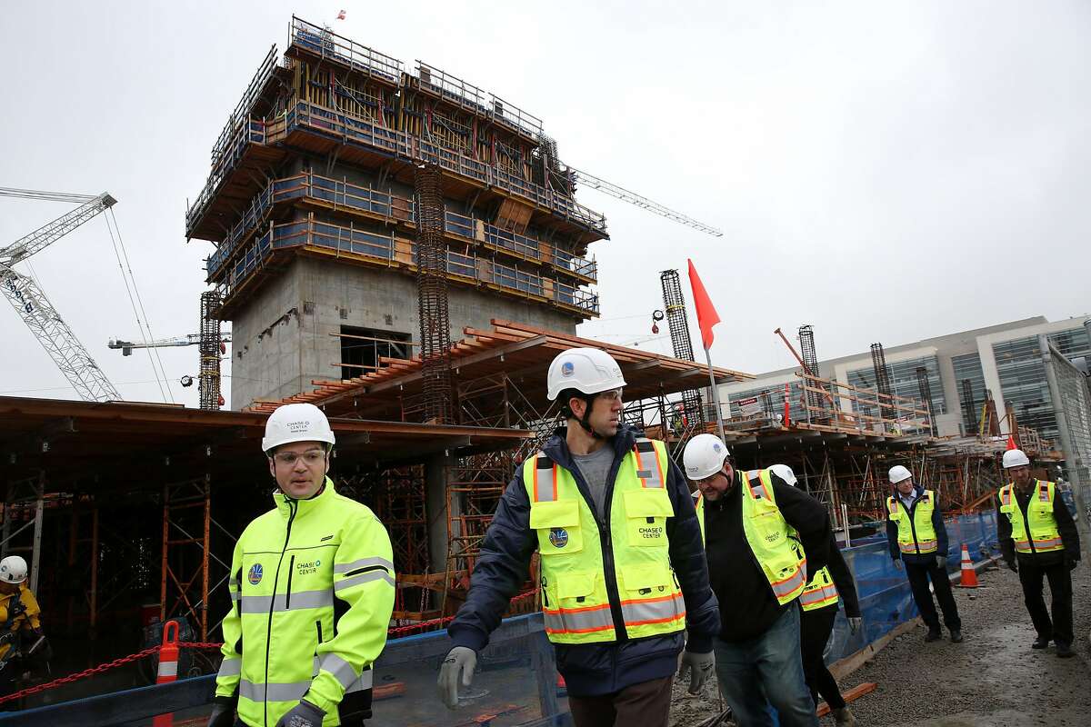 Bob Myers (center) visits the construction site of the Chase Center, Thursday, Jan. 18, 2018, in San Francisco, Calif. The Chase Center will be the new home court of the Golden State Warriors. The center is expected to be completed in 2019.
