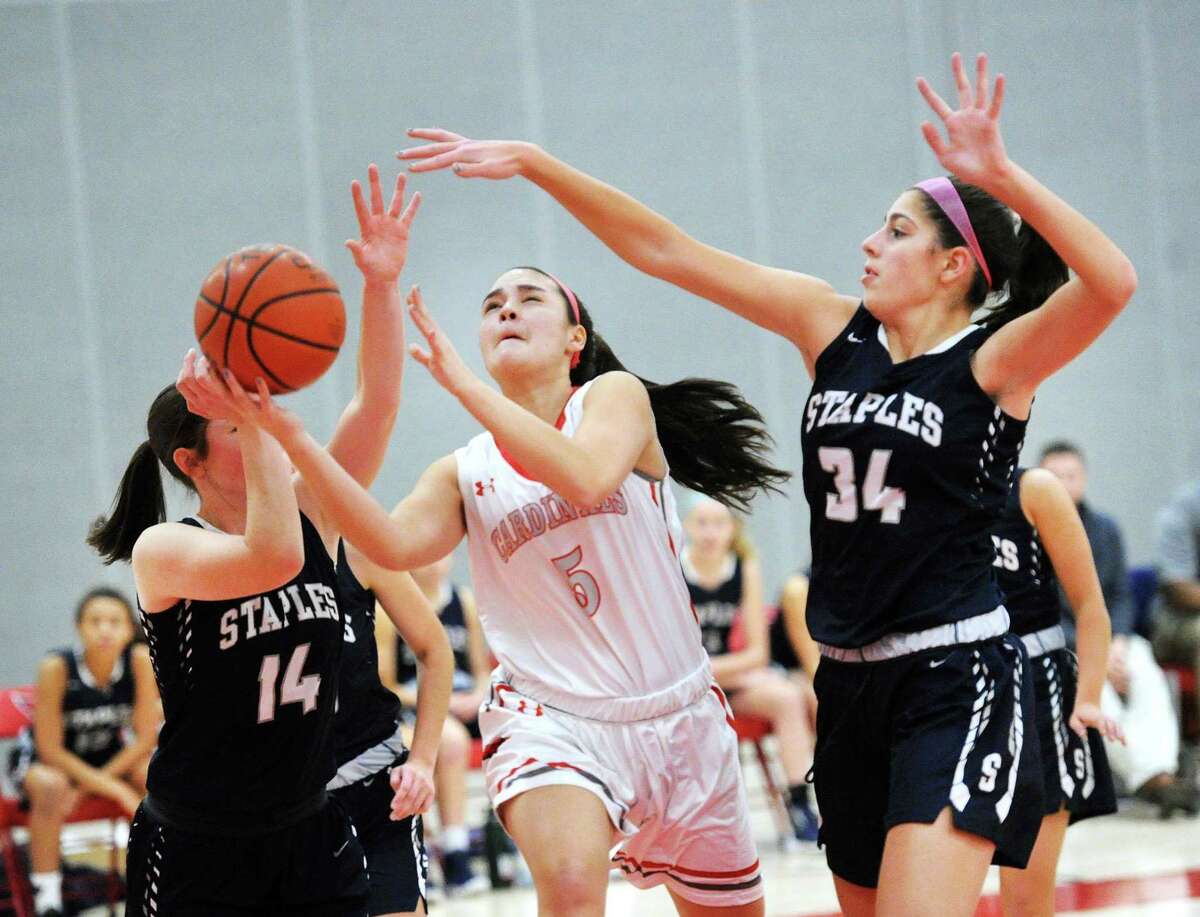 Arianna Gerig of (#34) Staples, right, and teammate, Sophie Smith (#14), left, attempt to stop a driving Kimberly Kockenmeister, center, of Greenwich, during the girls high school basketball game between Greenwich High School and Staples High School at Greenwich, Conn., Friday, Jan. 19, 2018.