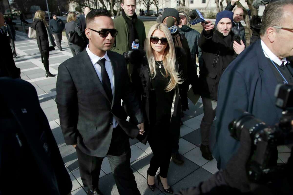 Michael "The Situation" Sorrentino, left, one of the former stars of the "Jersey Shore" reality TV show, walks with his fiancee Lauren Pesce while leaving the Martin Luther King, Jr., Federal Courthouse after a hearing, Friday, Jan. 19, 2018, in Newark, N.J. Sorrentino pleaded guilty to one count of tax evasion and admitted concealing his income in 2011 by making cash deposits in amounts that wouldn't trigger federal reporting requirements. He and his brother, Marc, were charged in 2014 and again last year with multiple counts related to nearly $9 million in income from the show. (AP Photo/Julio Cortez)