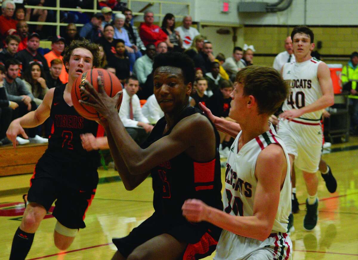 Edwardsville’s Jaylon Tuggle, left, drives to the basket during Friday’s game against Salem in the semifinals of the Salem Invitational.