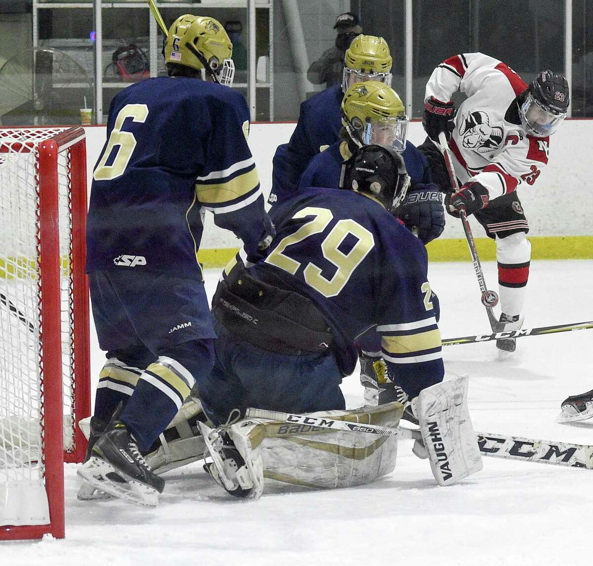New Canaan Quinn McMahon (23) pops a shot in for a score against Notre Dame-Fairfield goalie Andrew Jones (29) in a FCIAC boys hockey game at the Darien Ice House in Darien, Conn. on Saturday, Jan. 20, 2018.