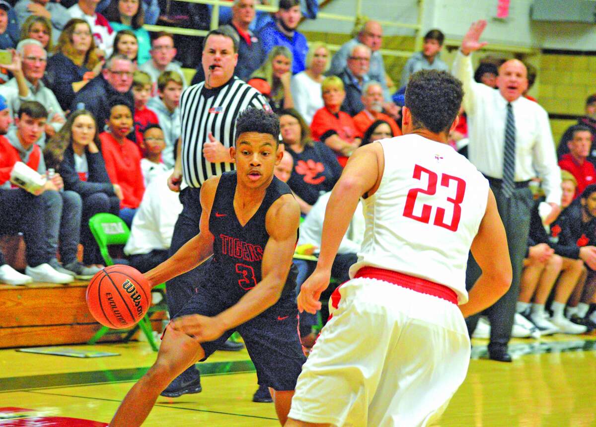 Edwardsville junior Malik Robinson, left, tries to dribble past a Centralia defender during the first quarter of Saturday’s championship game at the Salem Invitational.