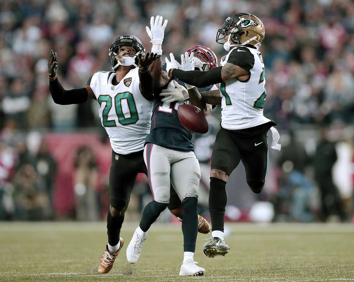 Jacksonville Jaguars cornerbacks Jalen Ramsey (20) and A.J. Bouye (21) break up a pass intended for New England Patriots wide receiver Brandin Cooks (14) during the second half of the AFC championship NFL football game, Sunday, Jan. 21, 2018, in Foxborough, Mass. (AP Photo/Charles Krupa)