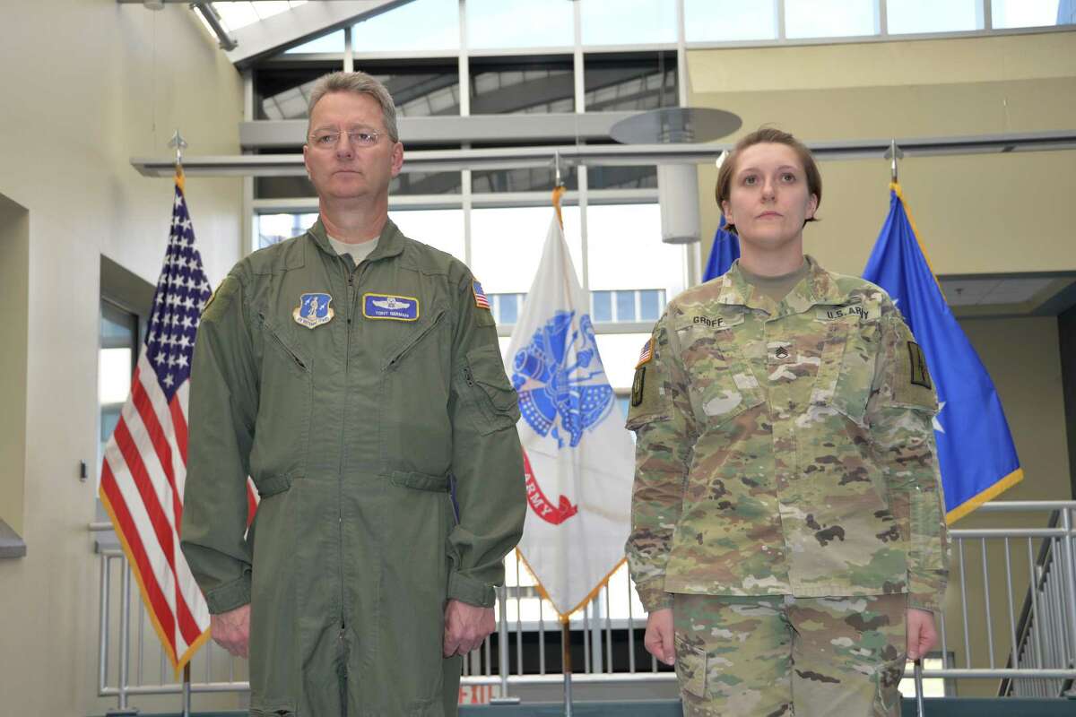 Army National Guard Staff Sgt. Melanie Groff stands at attention with Maj. Gen. Anthony German, the adjutant general of the New York National Guard, before she received a Meritorious Service Medal at State Division of Military and Naval Affairs Headquarters in Latham. (Capt. Jean Marie Kratzer / Army National Guard)
