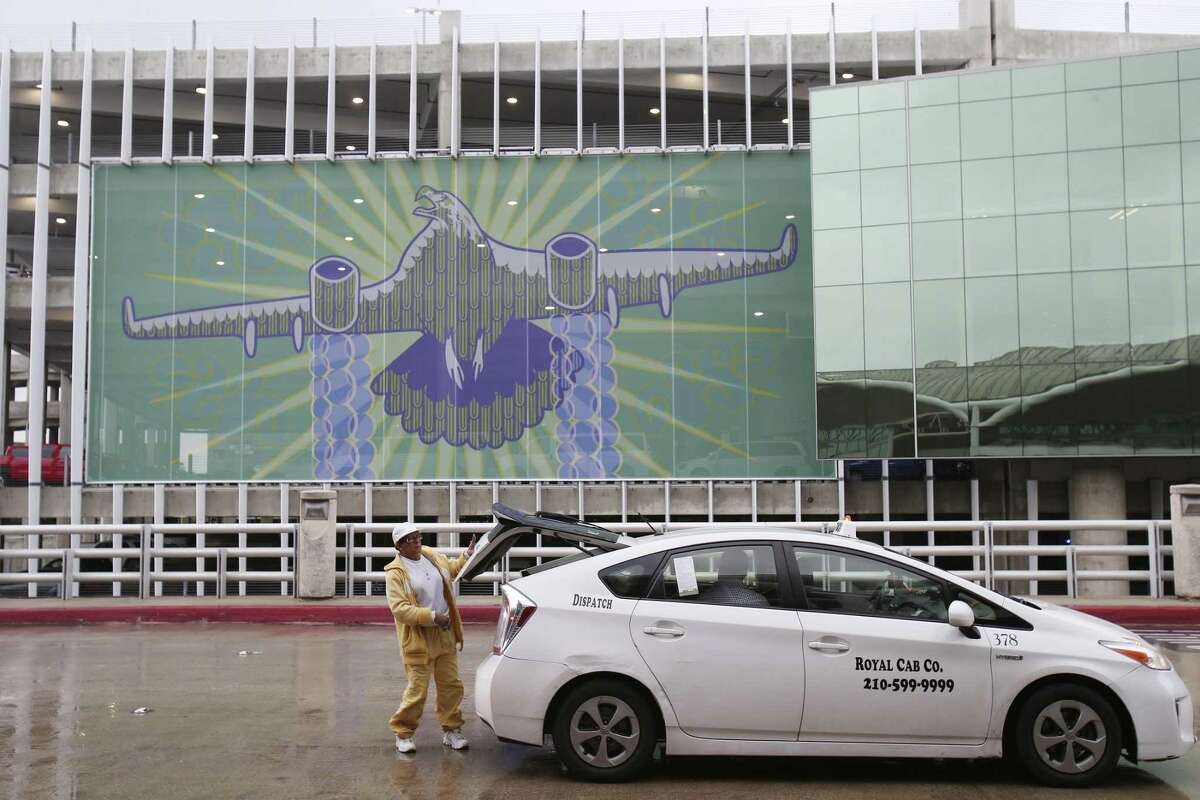 With the “¡Adelante San Antonio!” mural as a back- drop, Linda Thomas drops off an airport traveler.