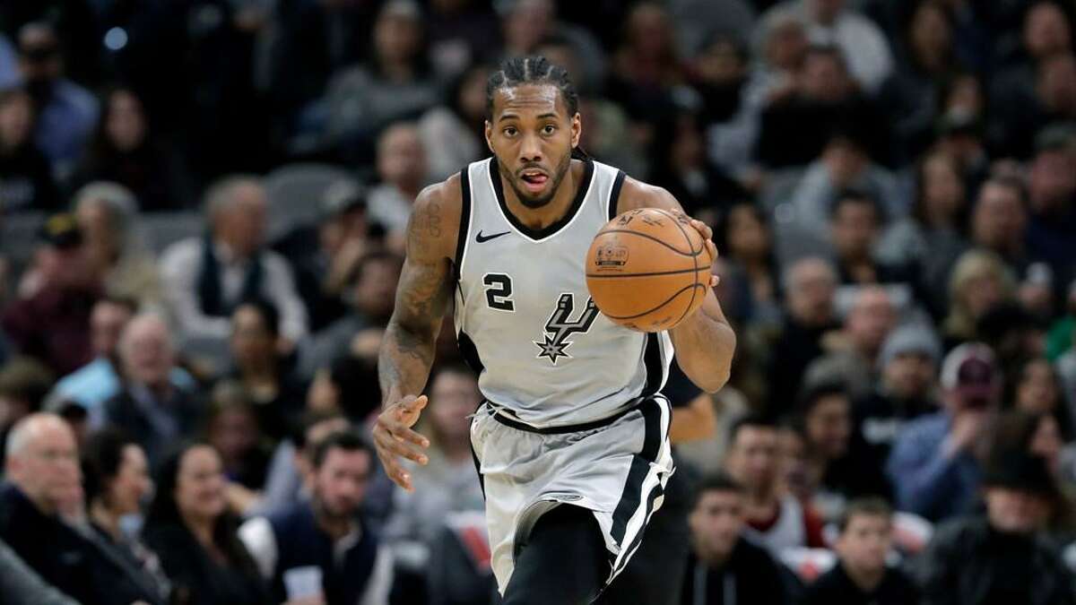 Spurs forward Kawhi Leonard dribbles during a Jan. 13, 2018 game against the Denver Nuggets in San Antonio. Injuries have limited his availability this season.