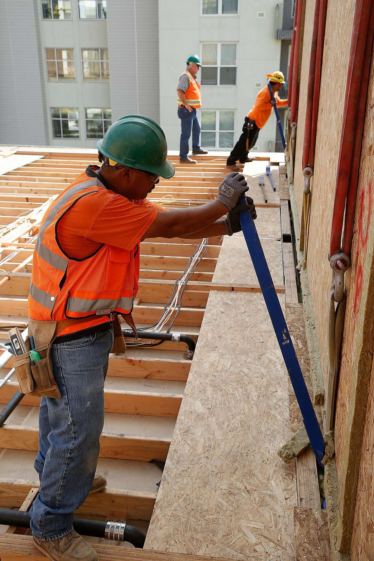 Construction workers place a modular housing unit of the 136-unit rental housing project taking place in the Bayview in San Francisco, Calif., on Monday, September 28, 2015.