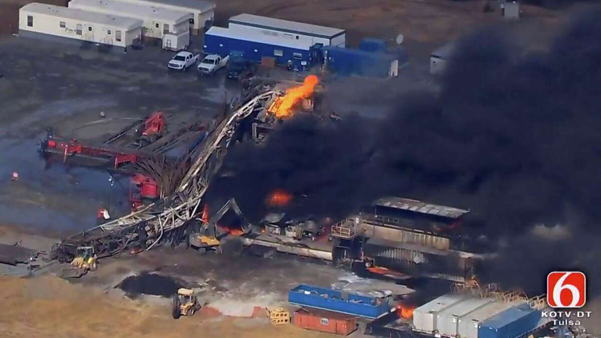 In this photo provided from a frame grab from Tulsa's KOTV/NewsOn6.com, fires burn at an eastern Oklahoma drilling rig near Quinton, Okla., Monday Jan. 22, 2018. Five people are missing after a fiery explosion ripped through a drilling rig, sending plumes of black smoke into the air and leaving a derrick crumpled on the ground, emergency officials said. (Christina Goodvoice, KOTV/NewsOn6.com via AP)