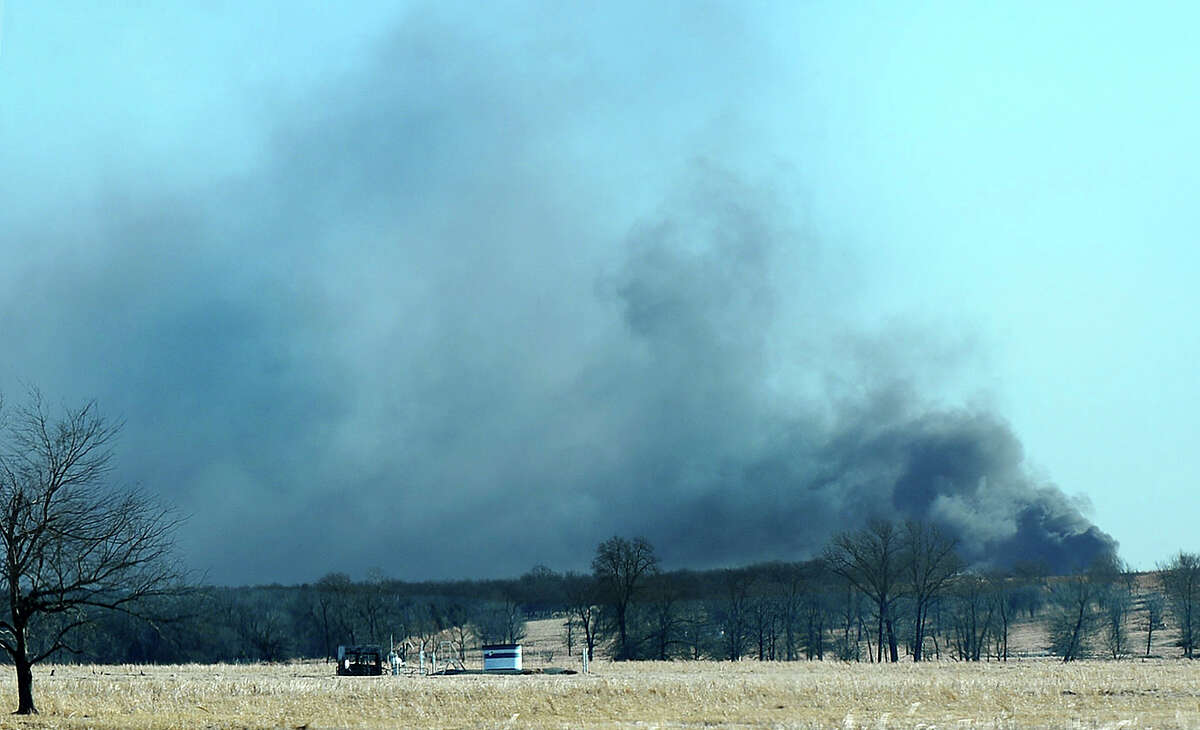 Smoke billows from the site of a gas well fire near Quinton, Okla., early Monday, Jan. 22, 2018. Several people are missing after a fiery explosion ripped through the eastern Oklahoma drilling rig, sending plumes of black smoke into the air and leaving a derrick crumpled onto the ground, an emergency official said. (Kevin Harvison/The McAlester News-Capital via AP)