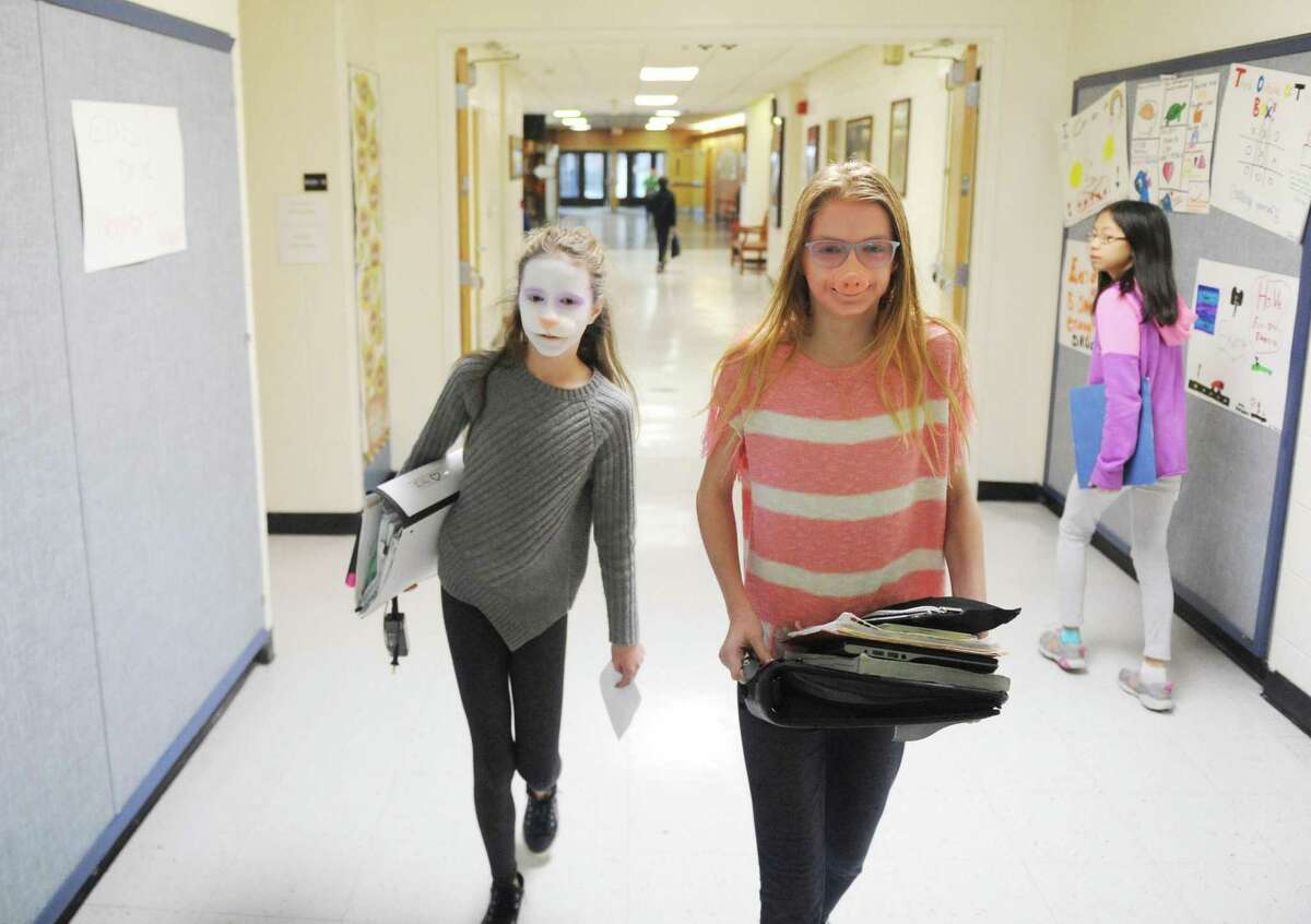 Seventh-graders Emily Phillipps, left, and Samantha Johnson walk down the hallways as a bunny and a pig after getting a special effects makeup makeover at Eastern Middle School in the Riverside section of Greenwich, Conn. Tuesday, Jan. 23, 2018. Makeup artist Tyler Green, a finalist on Syfy's "Face Off" SFX makeup reality show, gave demos transforming students into whimsical characters with the application of facial prosthetics and makeup.