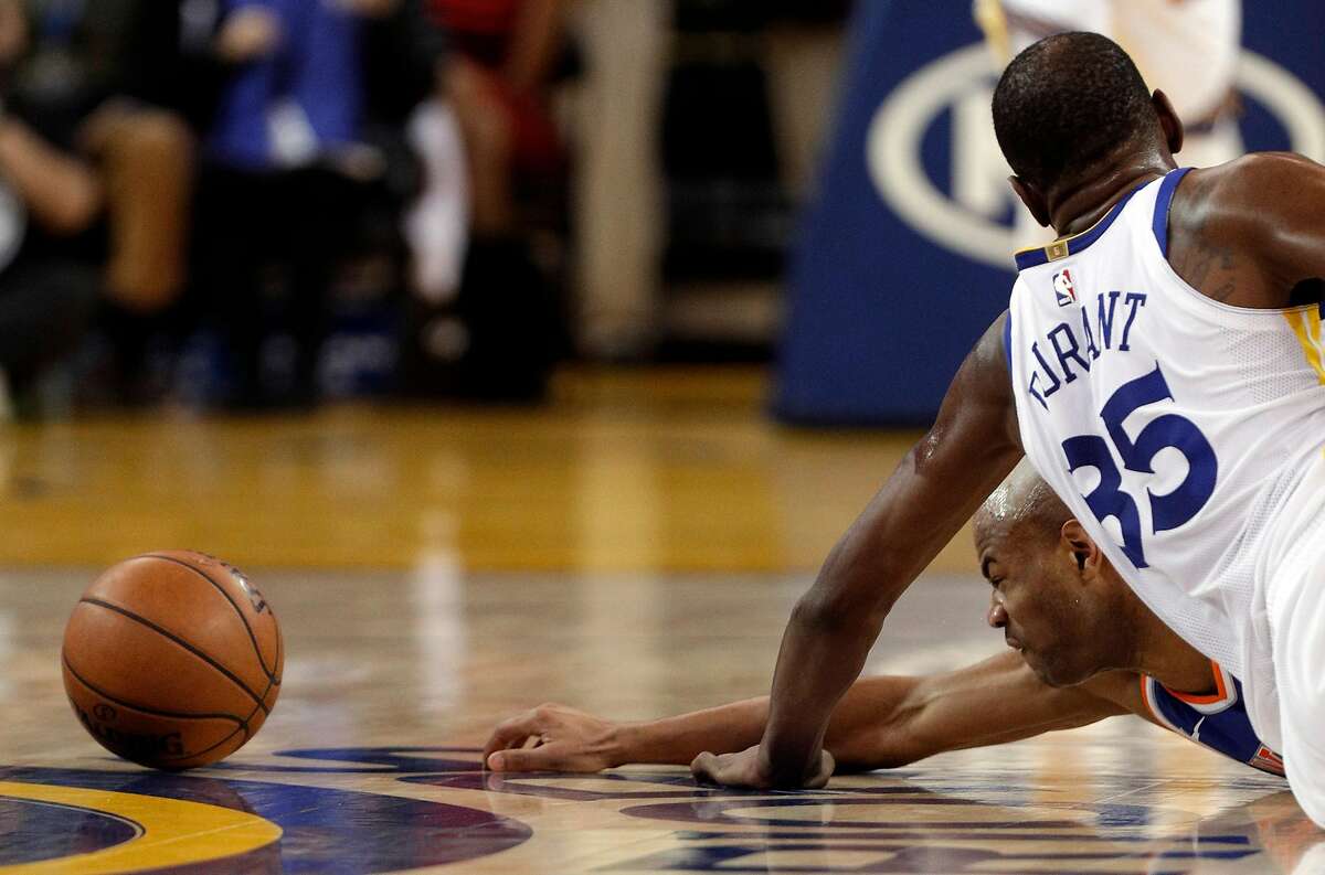 Jarrett Jack (55) and Kevin Durant (35) dive for a loose ball in the first half as the Golden State Warriors played the New York Knicks at Oracle Arena in Oakland, Calif., on Tuesday, January 23, 2018.