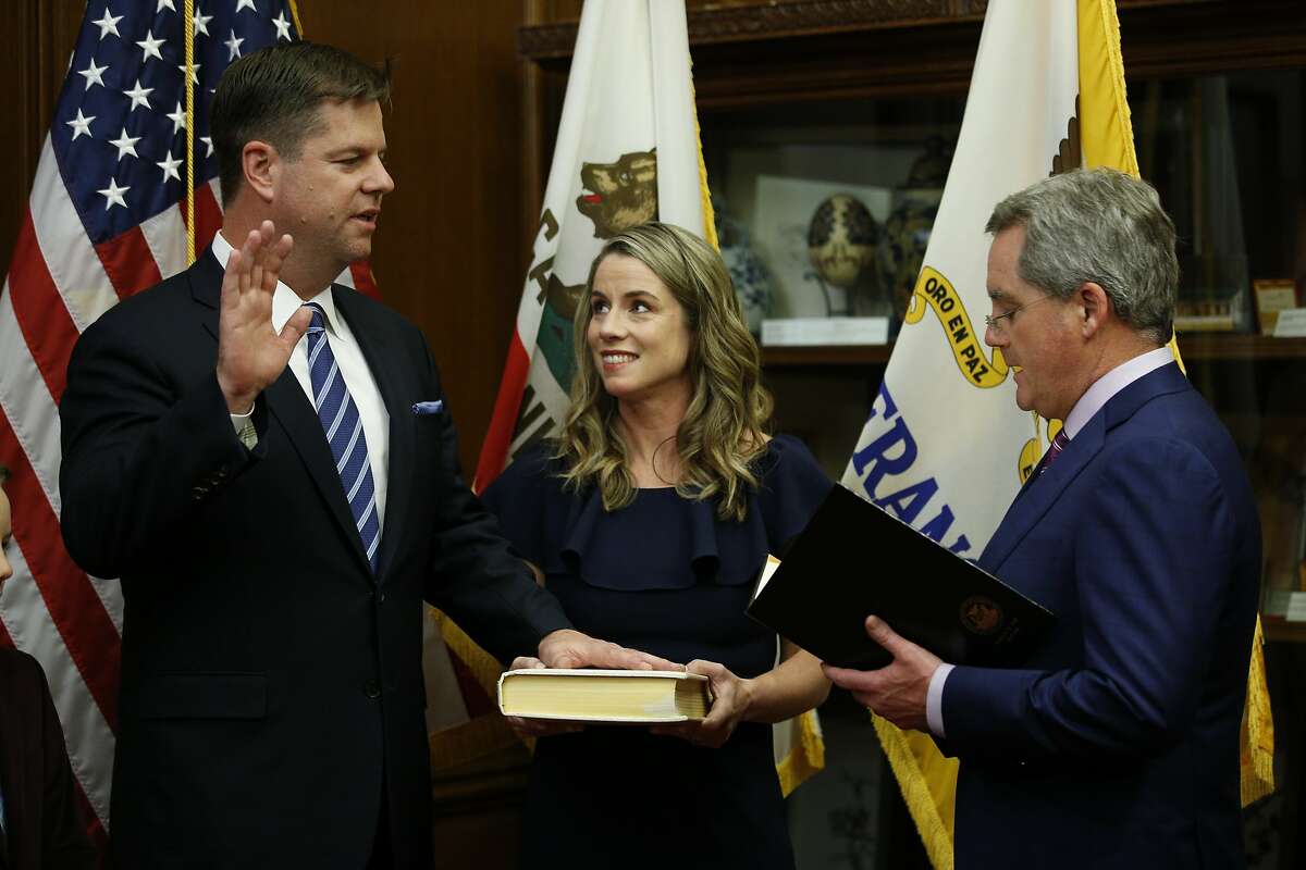 Mark Farrell is sworn in as interim mayor by City Attorney Dennis Herrera, as he stands with his wife and children at City Hall after being voted interim mayor by the board of supervisors, Tuesday, Jan. 23, 2018, in San Francisco, Calif.