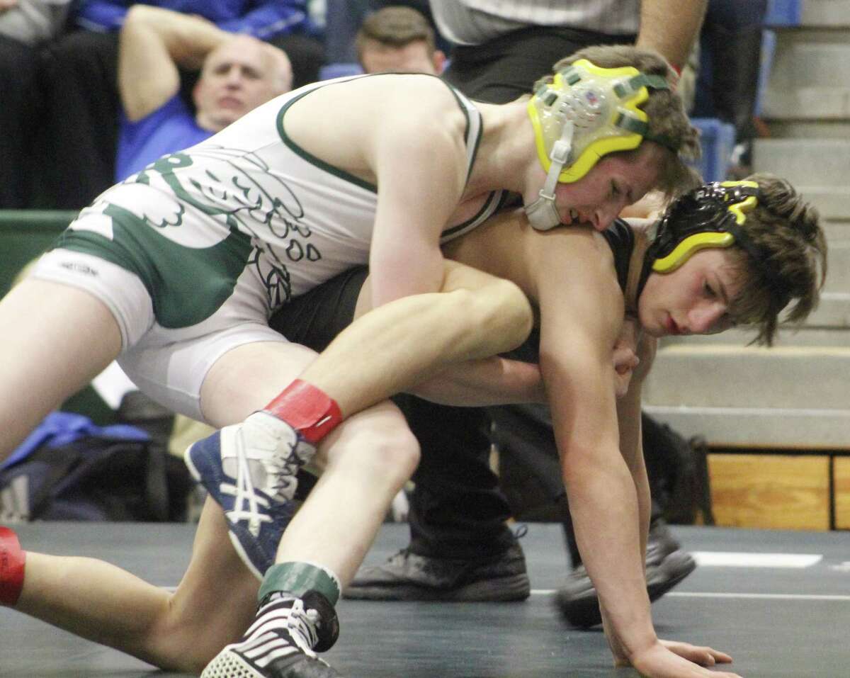 New Milford’s Brandon Leonard, top, and Amity’s Aiden Hebnert wrestle in the championship match at 120 pounds Saturday at New Milford High School.