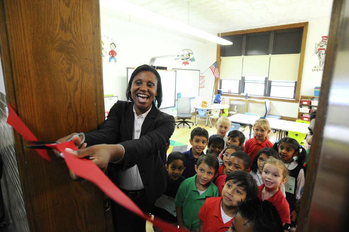 Assistant Superintendent Dr. Tamu Lucero cuts the ribbon to one of the classrooms at the new Strawberry Hill School in Stamford, Conn., on Thursday, September 1, 2016.