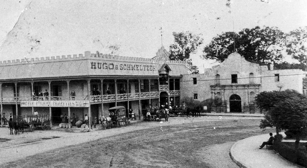 The Alamo, including the adjacent building built by Honore Grenet, circa 1880, on mission foundations. This photo shows it occupied by Hugo & Schmeltzer, wholesale groceries, which moved into it in 1884. Horses and buggies are in front of the store.