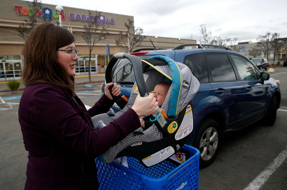 2018年1月24日星期三，在加州埃默里维尔的玩具反斗城/婴儿反斗城商店购物后，麦查尔·鲍威尔抱着3个月大的女儿克莱门汀上车。埃默里维尔店是该玩具零售商计划在全国关闭的约180家门店之一。